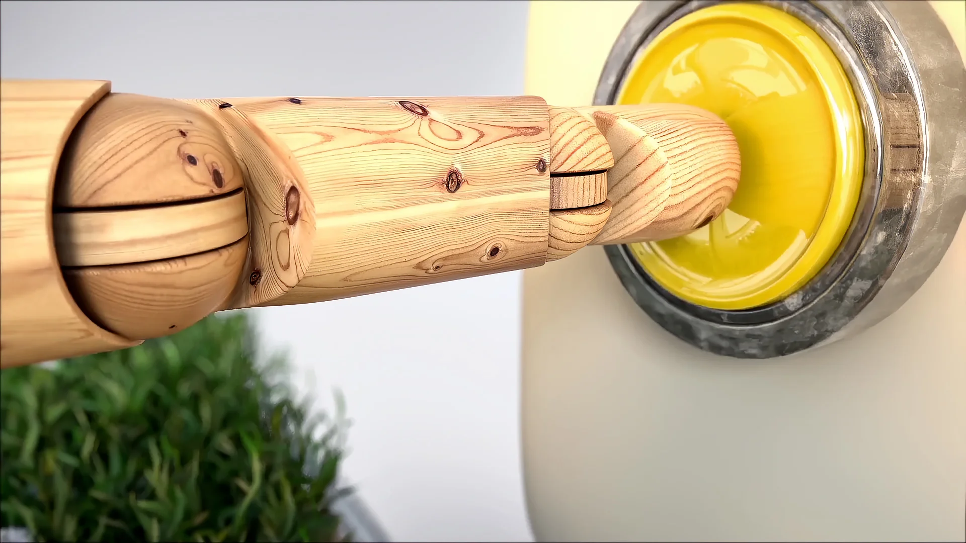 LabelExpo_Americas_Still11 Close-up of an articulated wooden mechanical hand pressing a yellow button in the chain reaction machine.